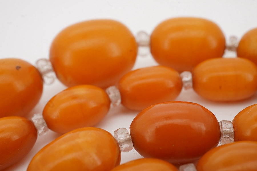 A single strand graduated oval amber bead necklace, with paste spacers, 44cm, gross weight 26 grams, one clasp missing.